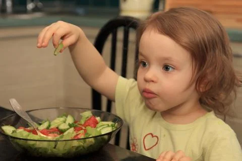 A girl eats vegetable salad. Fotos Stock