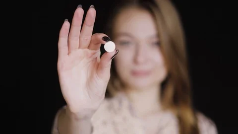 The girl eats vitamins in the form of a pill. She holds a pill in her hand and Video stock 88913369