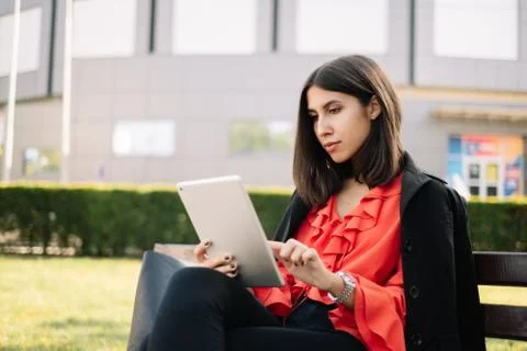 Girl with elegant clothes using tablet in park Foto stock