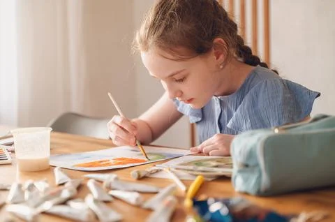 Girl engaged in creative work, drawing a picture with focus and imagination Stock Photos
