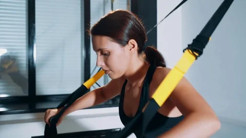 Girl is engaged in the hall using TRX loops. Stock-Footage 115079740