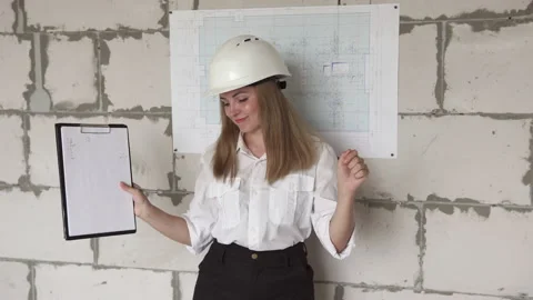 The girl engineer builder is checking the drawings and rejoices at the success. Video stock 156732534