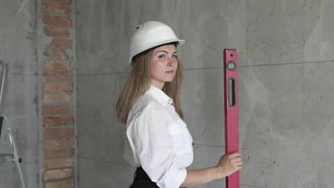 Girl engineer builder at a construction site holds a level in hands. Stock Footage 156615588