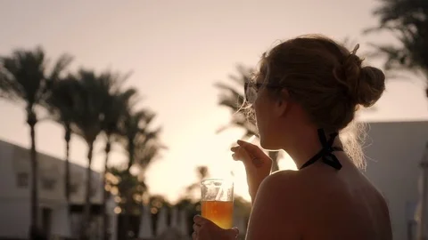 The girl is enjoying the sunset while drinking a colorful coctail Video stock 84078260