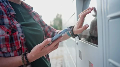 Girl Entering A Pickup Code On A Self-Service Parcel Locker Screen Stock Footage 347974987