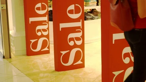 Girl entering shop. Three sales signs on shop entrance magnetic gates. Promotion Stock Footage