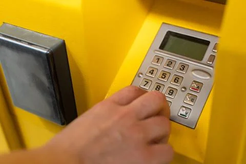 The girl enters the numeric pickup code for the parcel into the parcel machine Stock Photos