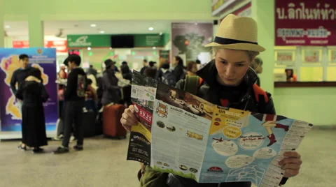 A girl examining a guide Stock Footage 64209413