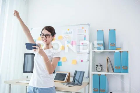 Girl exciting in office near her seat using smart phone Stock Photos