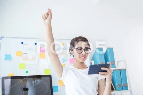 Girl exciting in office near her seat using smart phone Stock Photos