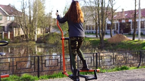 A girl exercises on an outdoor exercise machine. Stock Footage 340770749