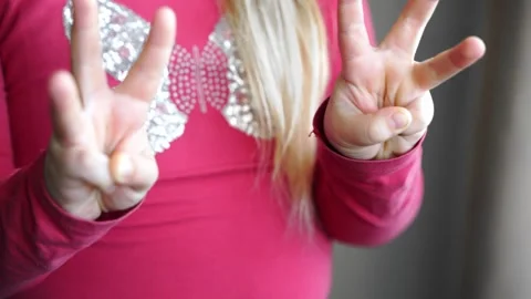 Girl extends hands forward, moves fingers. She spreads fingers wide, changes Stock Footage 303887549