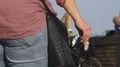Girl with extra weight walking down street and smoking holding cigarette in hand HD Footage