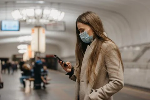 A girl in a face mask to avoid the spread of coronavirus at the subway statio Stock Photos