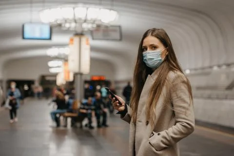 A girl in a face mask to avoid the spread of coronavirus at the subway statio Stock Photos