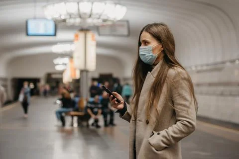 A girl in a face mask to avoid the spread of coronavirus at the subway statio Stock Photos