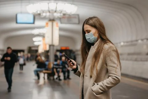 A girl in a face mask to avoid the spread of coronavirus at the subway statio Stock Photos