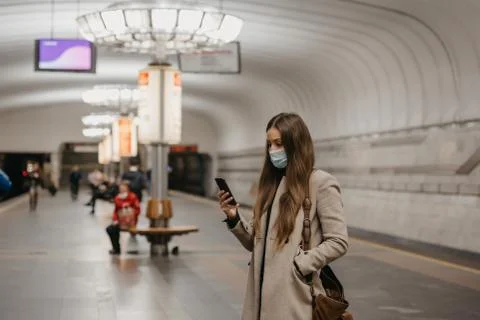 A girl in a face mask to avoid the spread of coronavirus at the subway statio Stock Photos