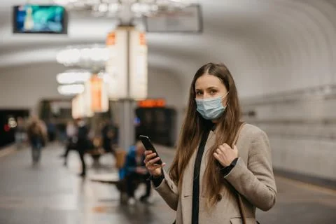 A girl in a face mask to avoid the spread of coronavirus at the subway statio Stock Photos