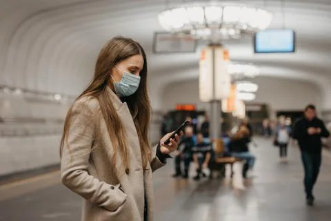 A girl in a face mask to avoid the spread of coronavirus at the subway statio Stock Photos