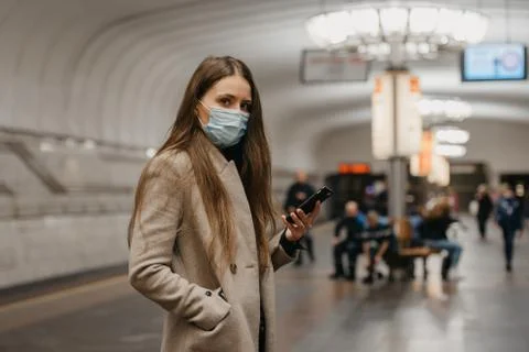 A girl in a face mask to avoid the spread of coronavirus at the subway statio Stock Photos