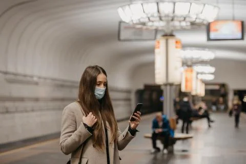 A girl in a face mask to avoid the spread of coronavirus at the subway statio Stock Photos