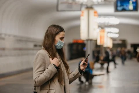 A girl in a face mask to avoid the spread of coronavirus at the subway statio Stock Photos