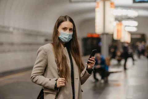 A girl in a face mask to avoid the spread of coronavirus at the subway statio 스톡 사진