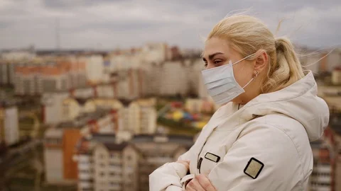 A girl in a face mask looking to the sky and breathing. Slow motion Stock Footage 127591978