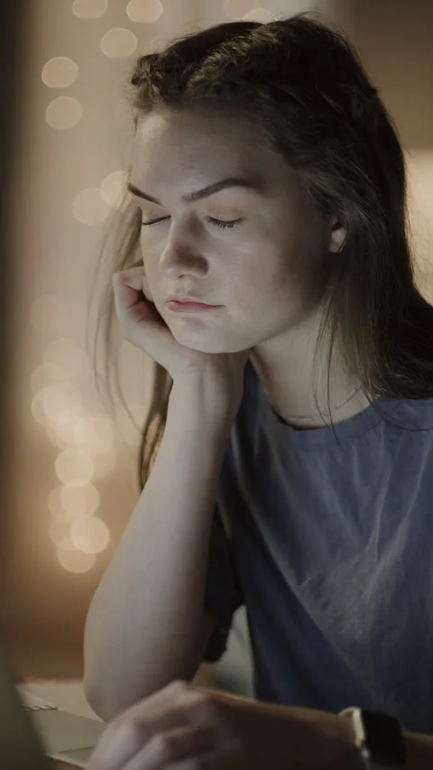 Girl falling asleep while studying on laptop at night  - vertical video / Cedar Stock Footage 254706411