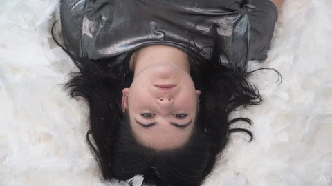 Girl falling down on white feathers in slowmotion Stock Footage 124275228