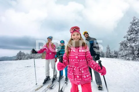 Girl with family on ski slope on vacation in mountain Stock Photos