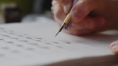 A girl fills a calligraphy notebook with beautiful symbols Stock Footage