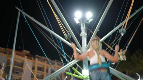 Girl flipping upside down on bungee ride Stock Footage 313482721