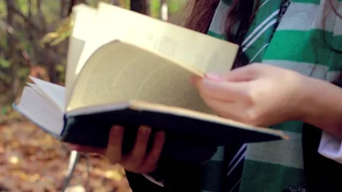 A girl flips through a thick  Stock Footage 142002778