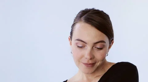Girl flirts looking at camera white studio Stock Footage