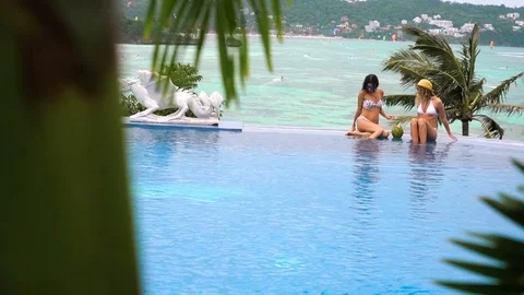 Girl floating in a swimming pool. splash around in the swimming pool, with a Stock Footage 72352553