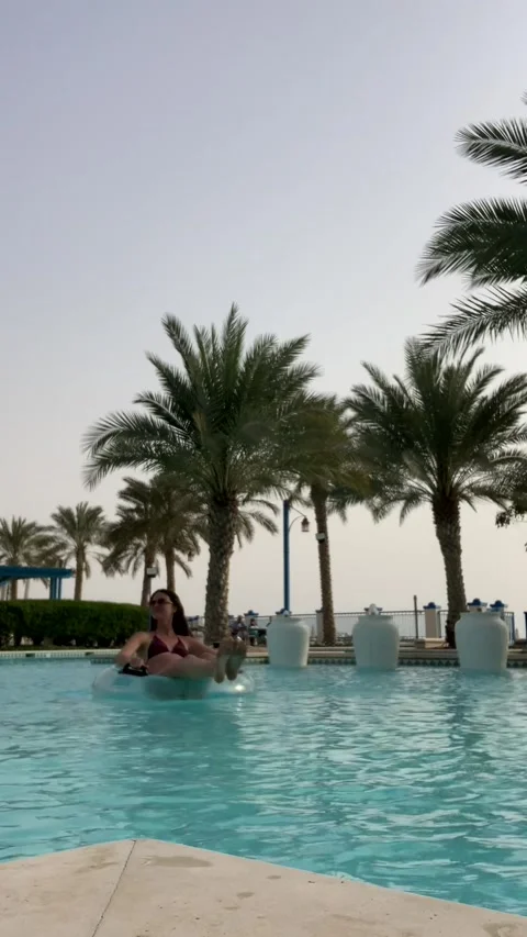 A girl floats on an inflatable ring in a pool. Video stock 319769377