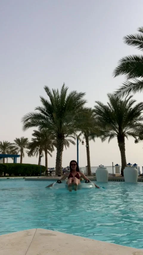 A girl floats on an inflatable ring in a pool.  Video stock 319769380