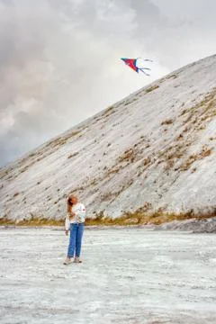 Girl flying a kite in the mountains. Stock Photos