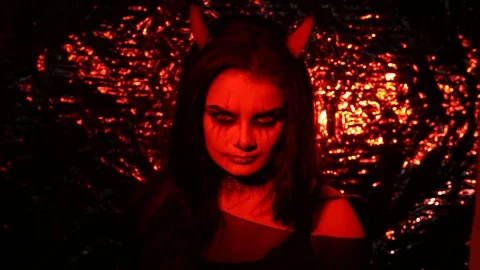 Girl in the form of a devil with horns. Image of halloween in red light. Contact Stock Footage 114552895