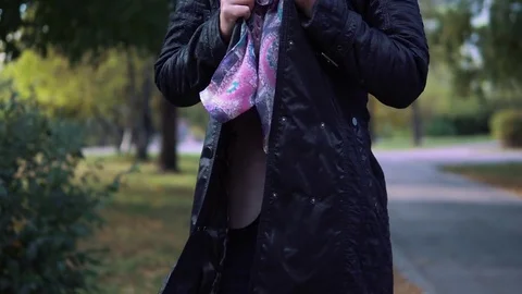 The girl froze in the autumn Park. young woman wrapped in a scarf and breathes Stock Footage