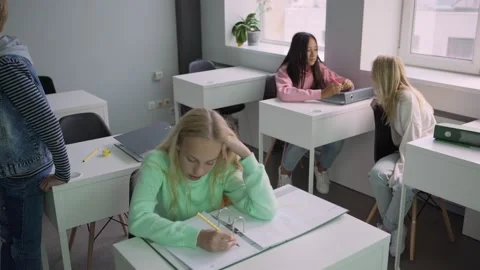 Girl fulfilling assignment during break in school Stock Footage 142495476