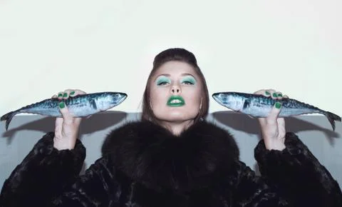 Girl in a fur coat with fish Stock Photos