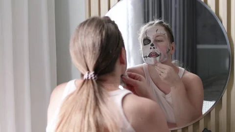 Girl gently cleans creative makeup design while reflecting in stylish mirror. Stock Footage 291938387