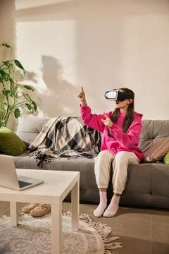 Girl gesturing in air while exploring interactive learning environment in VR Stock Photos