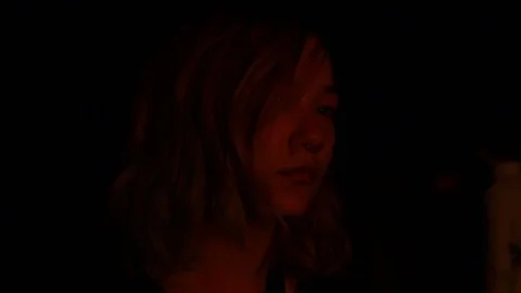 Girl gets lit up red from the fire she's watching Stock Footage 122801474