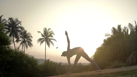 Girl gets out of revolved triangle asana on road slow motion 스톡 동영상 112263674