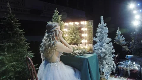 A girl is getting ready in front of the mirror for a New Years and Christmas. Stock Footage 324137797