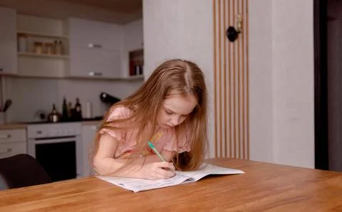The girl is getting ready for school, learning to write and count Stock Photos